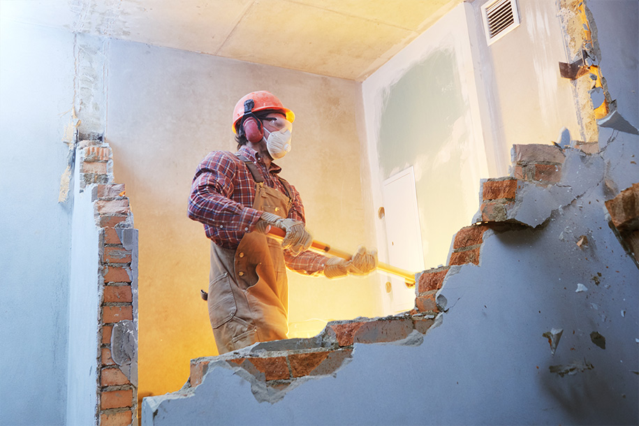 Abrissarbeiten – Arbeiter reißt mit einem Vorschlaghammer eine Wand ein – Talent Entrümpelung